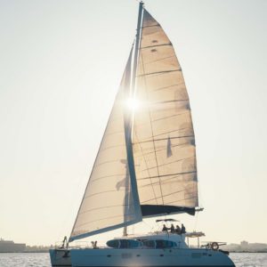 full catamaran with sun through sails