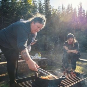 sitting and cooking over the fire